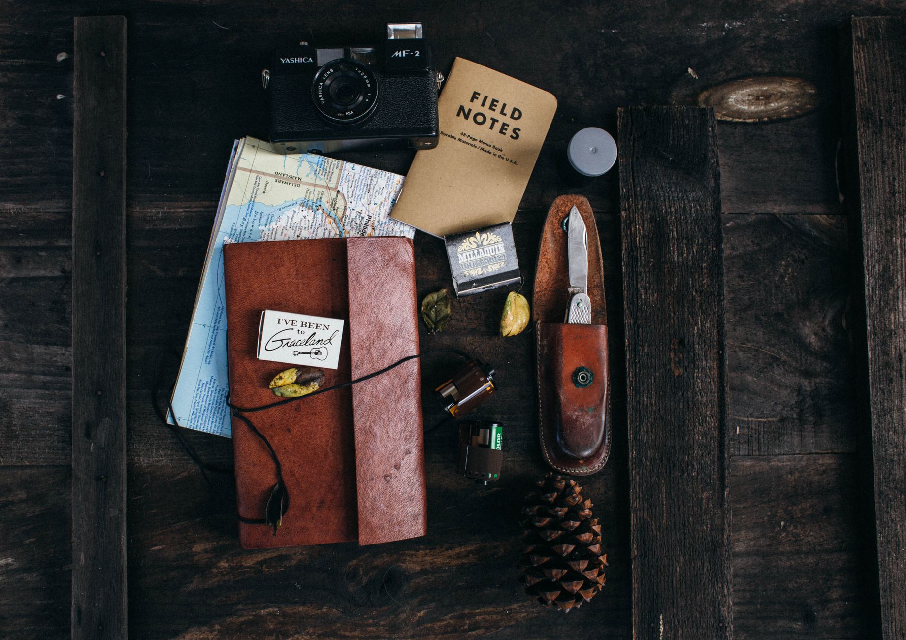 Travel writer taking notes at a wooden desk with film camera